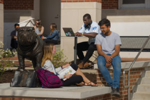Bulldog statue and students studying outdoors